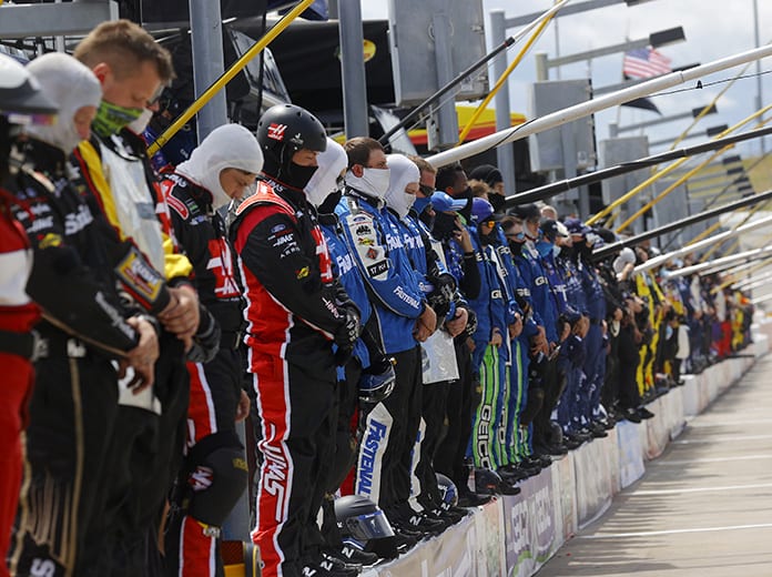 Crew members pause and stand on pit wall for a moment of listening in reflection of recent social unrest prior to the NASCAR Cup Series Folds of Honor QuikTrip 500 at Atlanta Motor Speedway. (Chris Graythen/Getty Images Photo)