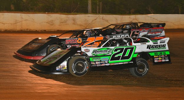 Jimmy Owens (20) passes Cory Hedgecock (23) and Jeff Neubert Monday night at 411 Motor Speedway. (Michael Moats Photo)